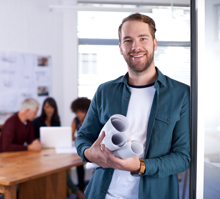 A portrait of a young architect standing in his office