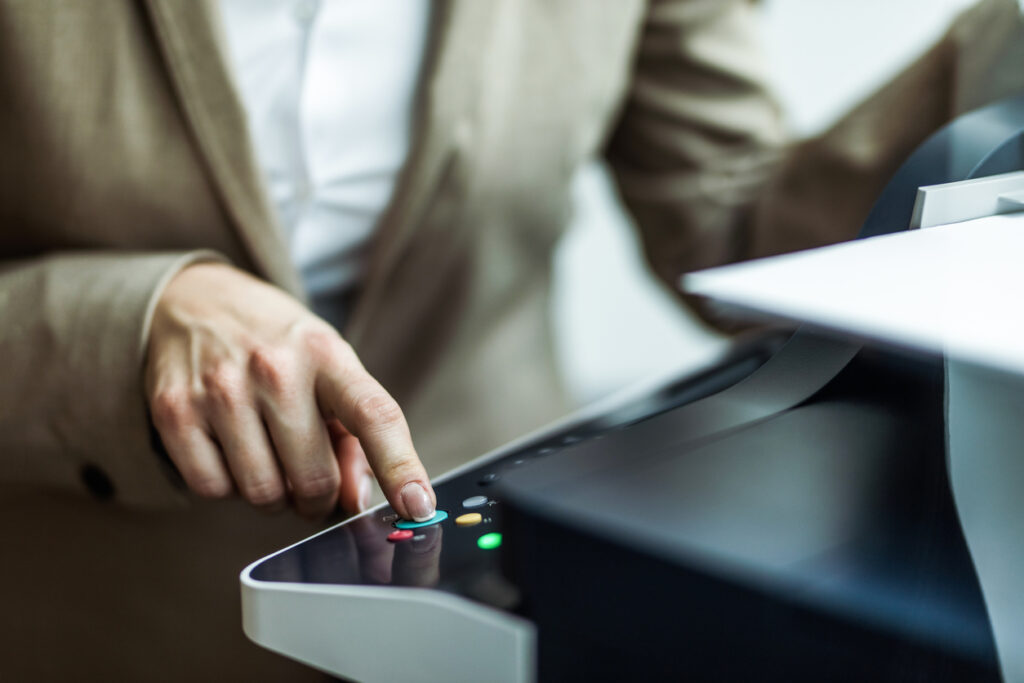 Close up of unrecognizable businesswoman pressing start button on fax machine.