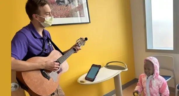 Playing guitar to child in the hospital