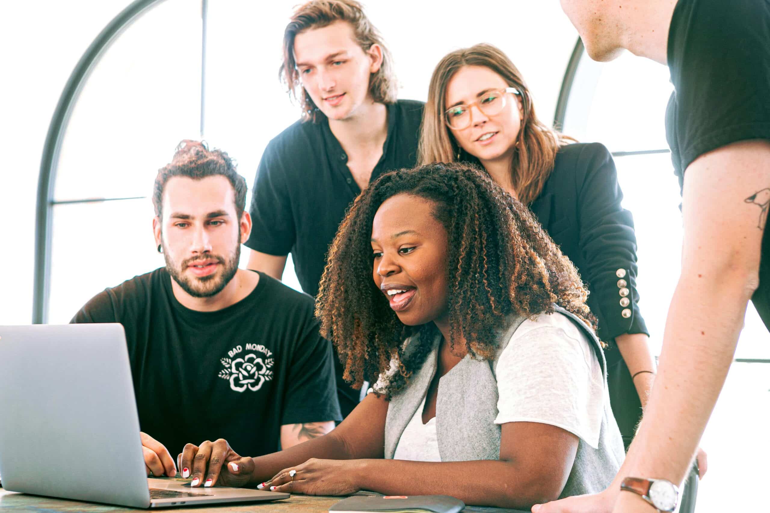 Group of people huddled around computer