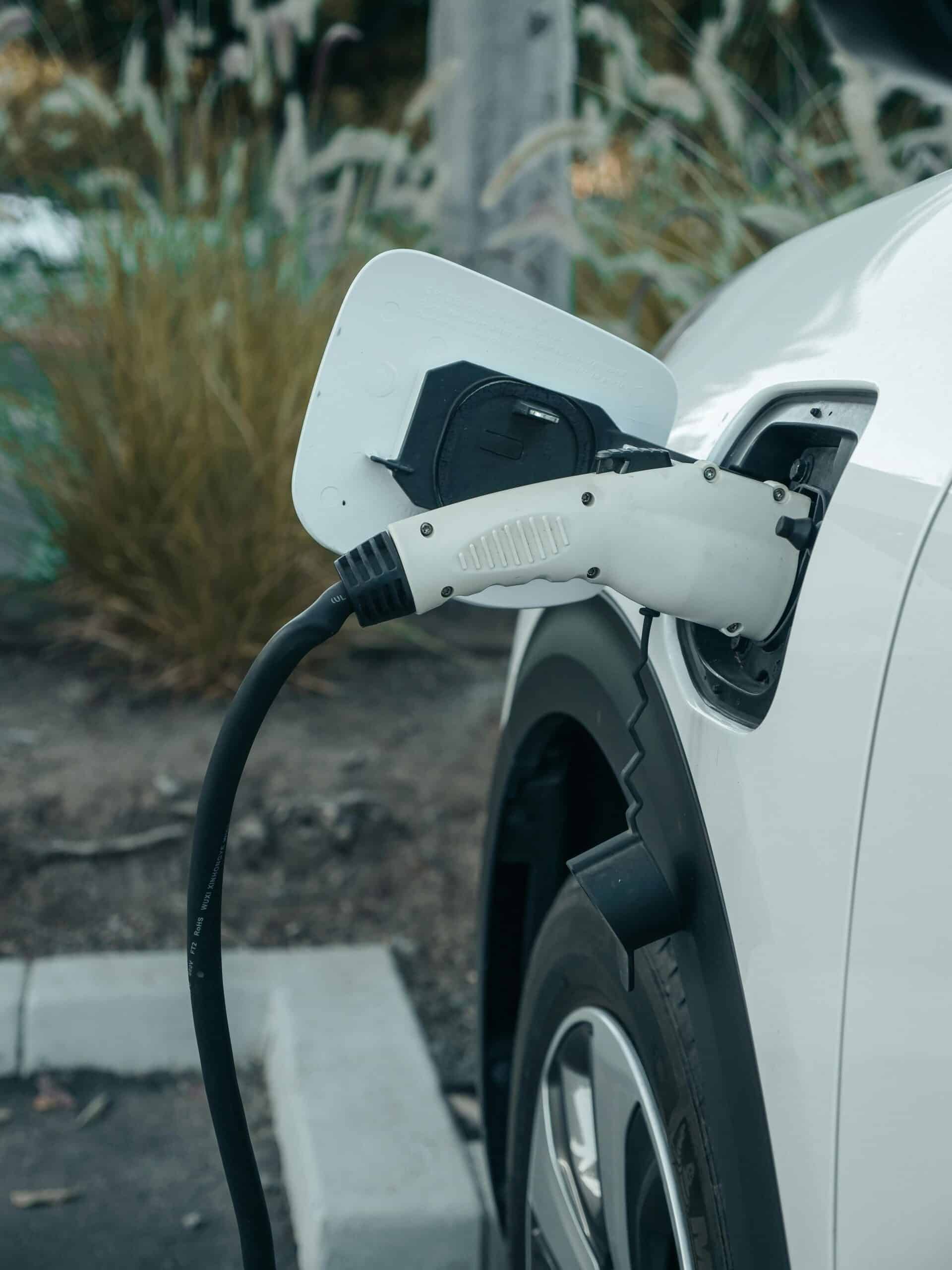 EV charger plugged into white car