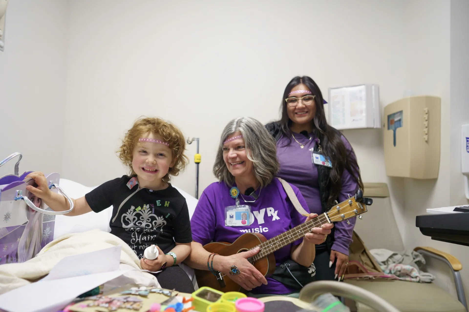 child and adults playing guitar